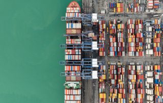 Container ship loaded with cargo docked at port, symbolizing biggest stock losers today hit by China’s 104% tariffs.